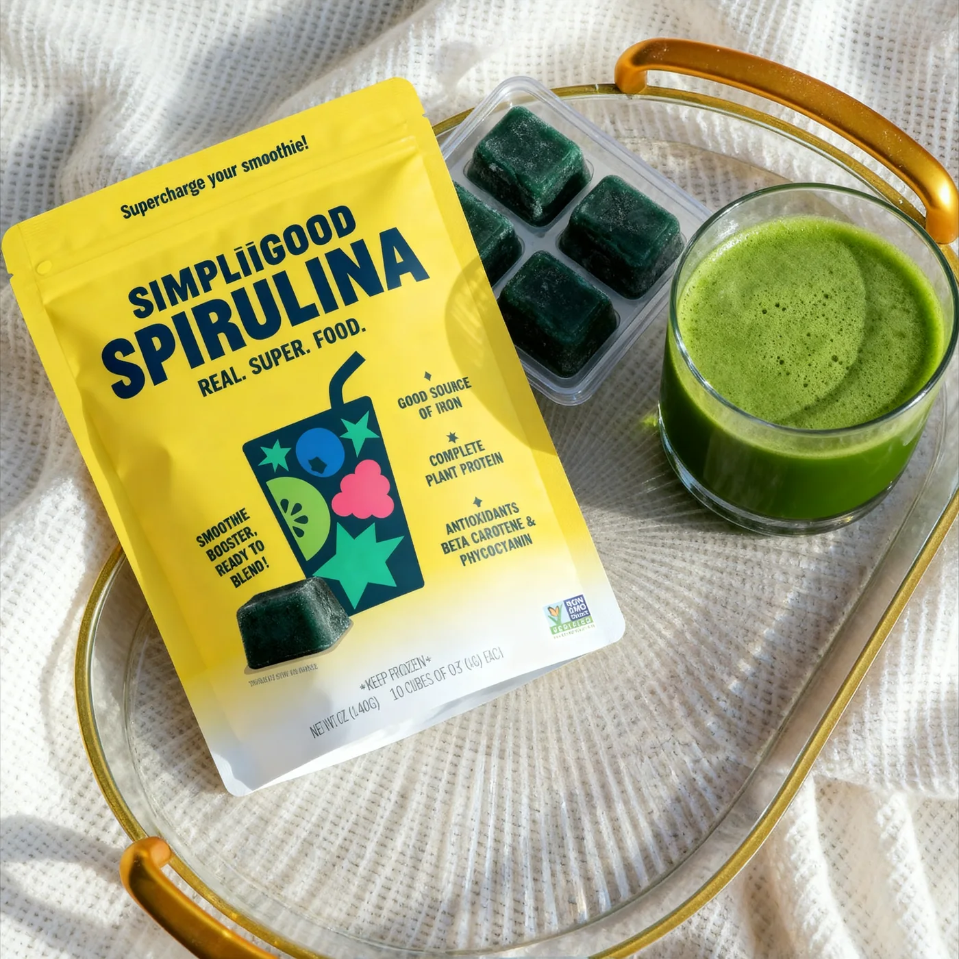 SimpliiGood pack with a tray of frozen spirulina cubes and a fresh green juice
